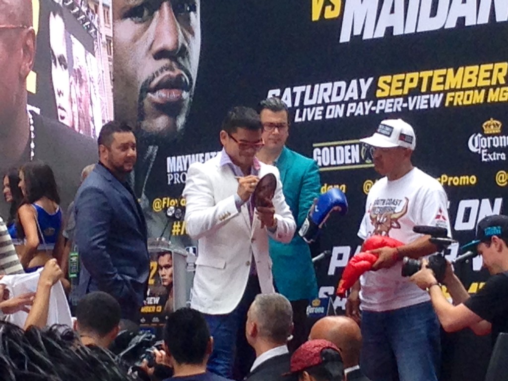 Marcos Maidana signing autographs on stage in front of the Times Square crowd.